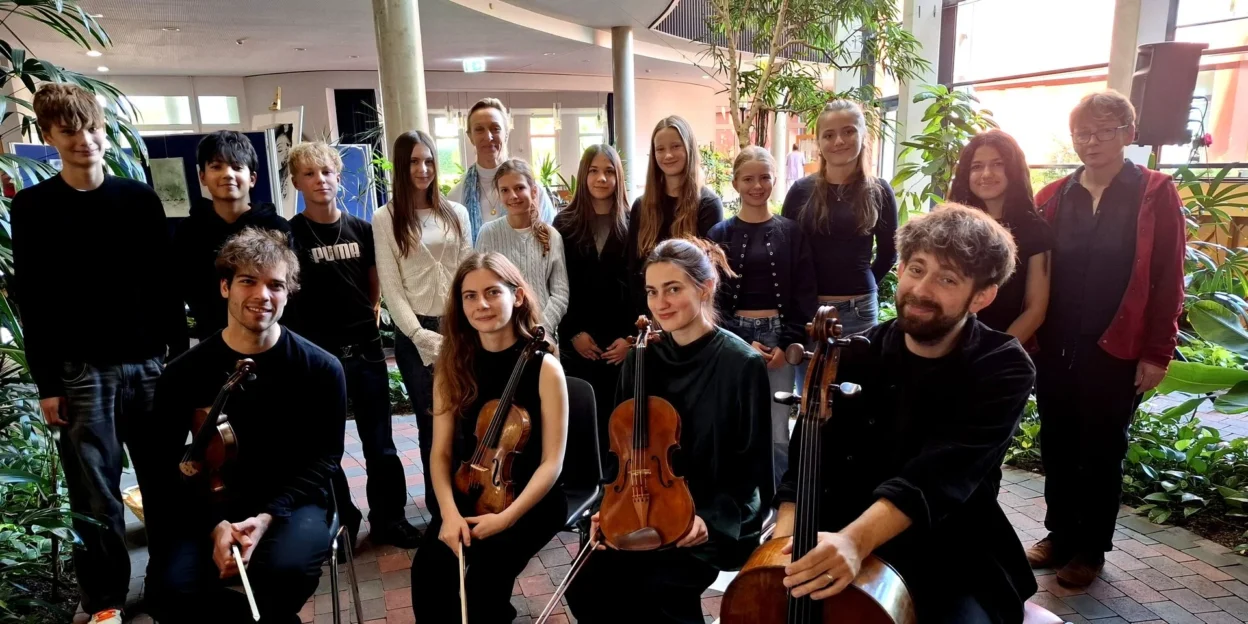 Musikerinnen und Musiker des fulda festivals mit Violinen, Bratsche und Cello gemeinsam mit Schülerinnen und Schülern des Domgymnasiums Fulda