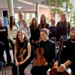 Musikerinnen und Musiker des fulda festivals mit Violinen, Bratsche und Cello gemeinsam mit Schülerinnen und Schülern des Domgymnasiums Fulda