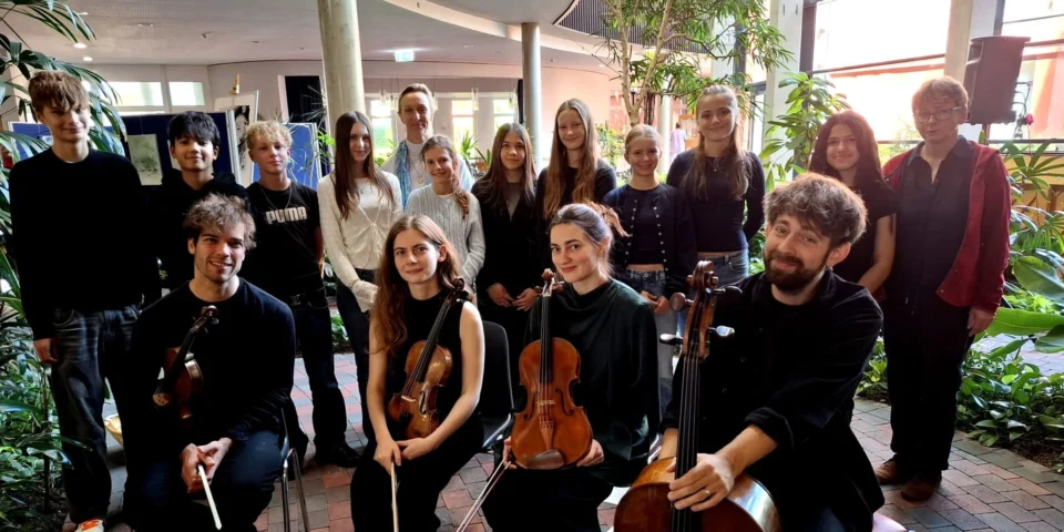 Musikerinnen und Musiker des fulda festivals mit Violinen, Bratsche und Cello gemeinsam mit Schülerinnen und Schülern des Domgymnasiums Fulda