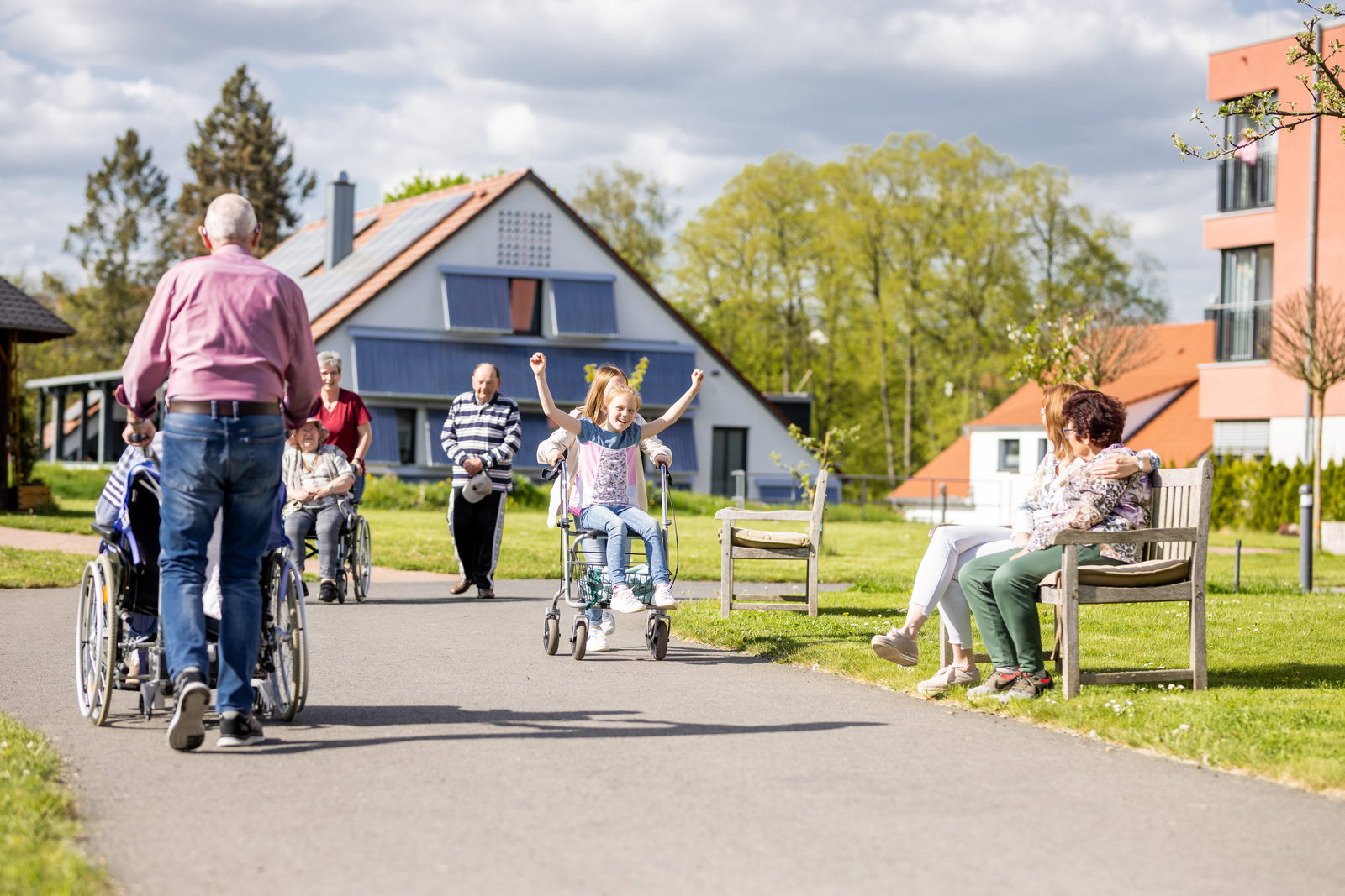Bewohnerinnen, Bewohner und Angehörige beim Spaziergang im Garten der Senioreneinrichtung St. Ulrich in Hünfeld